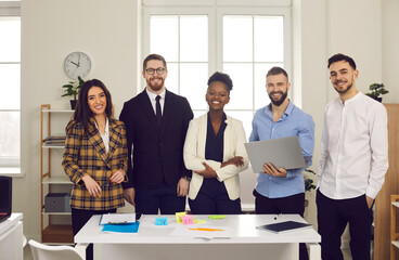 Teamwork in a friendly atmosphere. Portrait of a positive young multiracial team of startup project managers in the office. Concept of international relations and business.