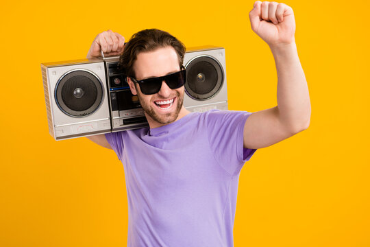 Photo of carefree cool guy hold boombox have party fun wear violet t-shirt isolated yellow color background
