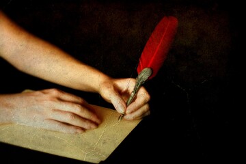 Close up on hands holding an old pen with red goose feather, ocher sheet on black background,...