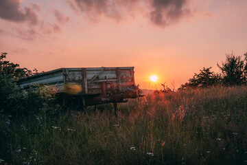 Ländlicher Sonnenuntergang alter Anhänger eines Traktors