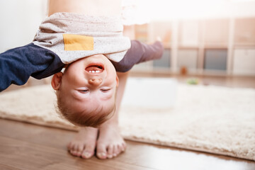 Mother holding upside down her laughing child. © candy1812