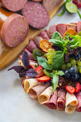 Meat plate on a white wooden background. Set of Salami. Cold cuts of different types of meat. Antipasto set platter. meat snack plat. vertical view