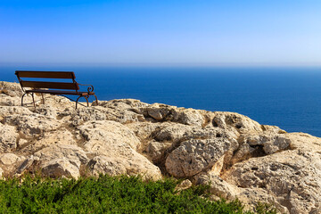 An empty bench at Cape Greco on the island of Cyprus. Relaxation overlooking the Mediterranean Sea.