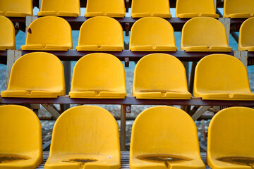 Yellow plastic seats on the podium of a small sports field