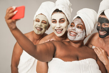 Multiracial women taking a selfie with smartphone - Multi generational people doing beauty treatment together