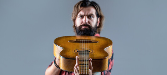 Music concept. Bearded guitarist plays. Play the guitar. Guitars and strings. Bearded man playing guitar, holding an acoustic guitar in his hands