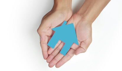 Hands holding paper house, family home protecting insurance concept