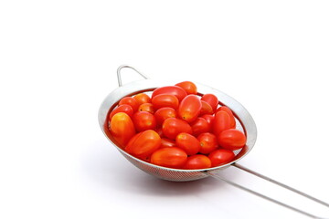 Group of fresh red tomatoes in metal basket on white background