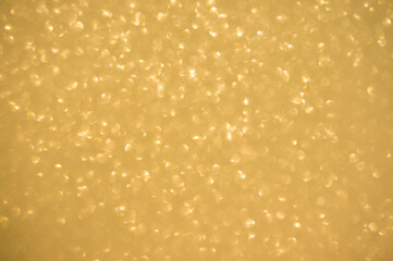 Gold glitters background. shimmering blur spot lights Bokeh Shiny gold light background.