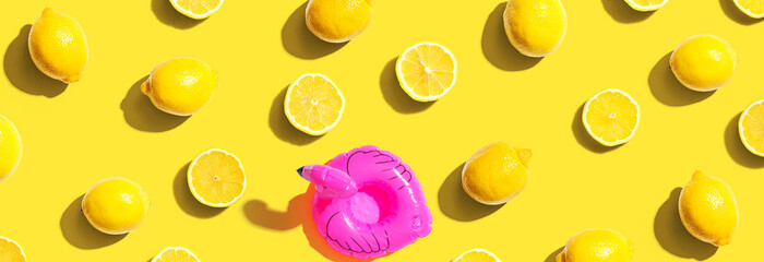 Summer concept with a pink flamingo float and lemons