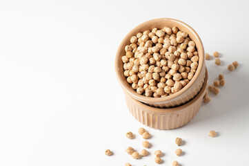 dry chickpeas, in a ceramic bowl on a white table, empty space for text