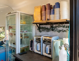 Coffee stall on wheels. Coffee kiosk in van. Glass transparent refrigerator and coffee makers....