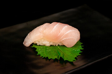 Suzuki sushi on oba leaves, Eating sushi at restaurant, japanese cuisine - obrazy, fototapety, plakaty