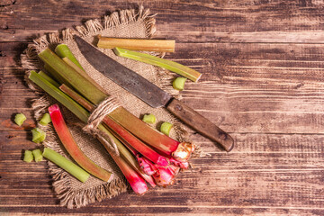 Fresh rhubarb stalks and cut pieces on a vintage wooden table