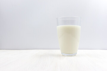 Glass of milk on a white wooden table