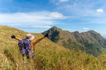 Obraz premium happy woman hiking on top mountain at Khao Chang Phueak, Thongphaphoom National Park, Kanchanaburi Province, Thailand. Subject is blurred, noise and color effect.