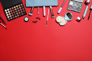 Decorative cosmetic products on red background, flat lay. Space for text
