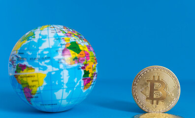 Bitcoin BTC crypto currency gold coin and Earth globe, worldwide new virtual money concept. Mining or blockchain technology