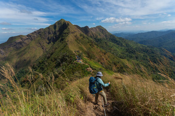 Fototapeta premium happy woman hiking on top mountain at Khao Chang Phueak, Thongphaphoom National Park, Kanchanaburi Province, Thailand. Subject is blurred, noise and color effect.