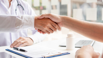 A male doctor and a male patient having a handshake after meeting the doctor’s appointment