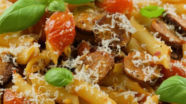 Sausage penne Pasta with tomato sauce, parmesan cheese and basil. rotating video