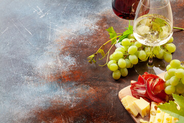 White and red wine glasses, grape and appetizer board