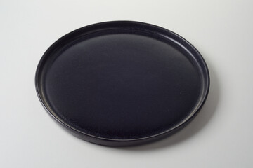 Circular clean black empty plate with raised rim