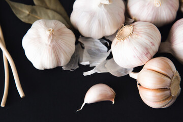 Garlic bulbs on black background, close-up. Organic garlic. Food background. Copy space. Selective focus.	