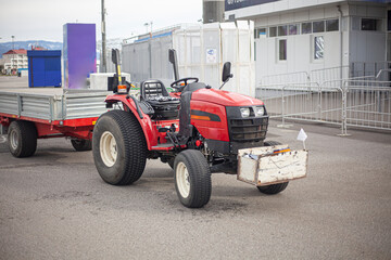 A small tractor transports a load. The machine is doing the job.