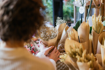 Hands of unrecognizable person choosing a bouquet in a flower shop.
