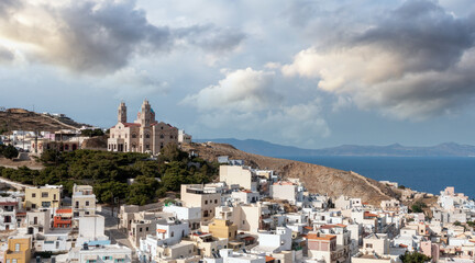 Obraz premium Syros island, Greece, aerial drone view. Ermoupolis and Ano Siros town cityscape, cloudy blue sky background.