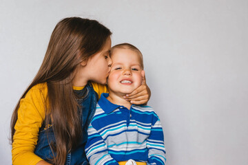 Child girl kisses the boy on the cheek. Children, communication, models concept.