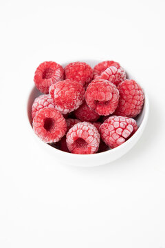 Frozen Raspberries in a white bowl on a white background