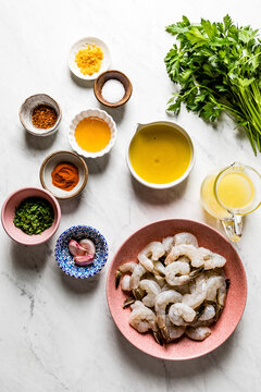 Shrimp in a homemade marinade ingredients, on a marble background