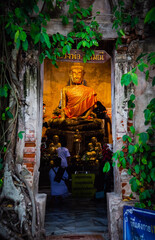 Old Buddha statue covered with trees roots in Wat Bang Kung Camp, Prok Bodhi Ubosot, in Samut Songkhram, Thailand