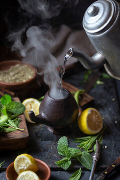 Latin American hot drink yerba mate in clay cup, herbs amd lemon