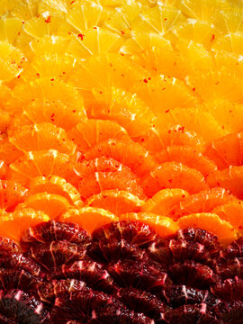 Detail image of a beautiful citrus tart with a gradient of red, orange and yellow citrus.