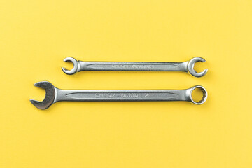 Wrenches on bright yellow background, steel hand work tools
