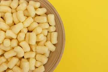sweet corn sticks in bowl isolated on yellow background