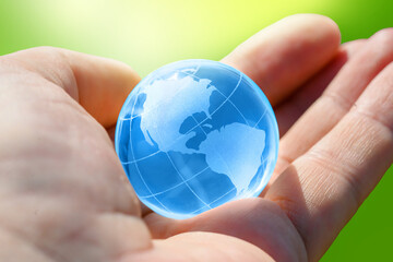 Blue Glass globe of the planet Earth in human hand