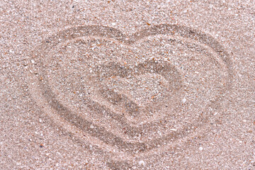 Fototapeta na wymiar a heart within a heart is drawn on the seashore with a stick on the sand. close-up