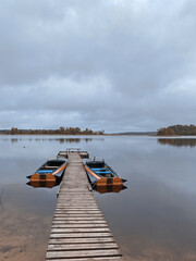Fototapeta premium Rowing boat on the shores of Lake Seliger. Walkway on a sandy beach on a cloudy day