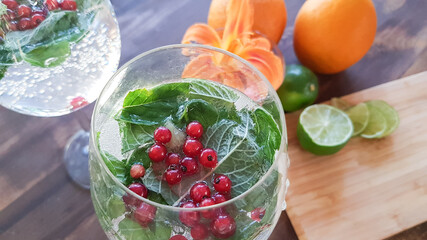 summer refreshing cocktail of lime and orange from red currant close-up