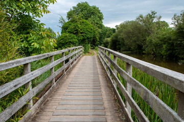 Fototapeta na wymiar Kintbury, Berkshire, UK. 2021, A pedestrian only footbridge crossing a waterway alongside the Kennet and Avon Canal.