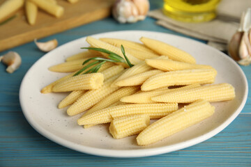 Fresh baby corn cobs on blue wooden table