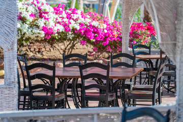 Fototapeta na wymiar Wooden table and chairs in beach cafe next to the red sea in Sharm el Sheikh, Egypt