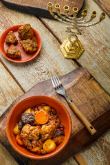 Jewish dish shut with meat on a wooden table near matzo and ingredients.