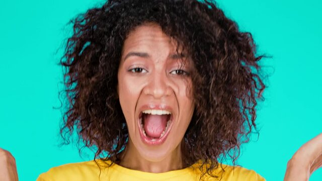 Young mixed race woman is very glad, she screaming WOW loud. Concept of surprise, great news, sales, profitable offer. Excited happy lady on teal studio background.
