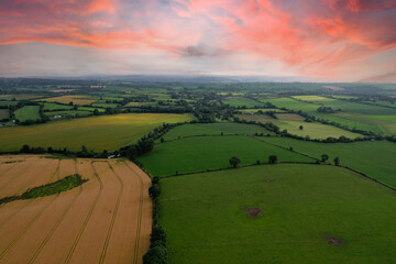 Aerial view of green and yellow farming fields in Ireland at sunset