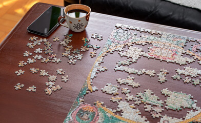 Cup of coffee, mobile phone and jigsaw puzzle pieces together. Stay at home concept. Home...